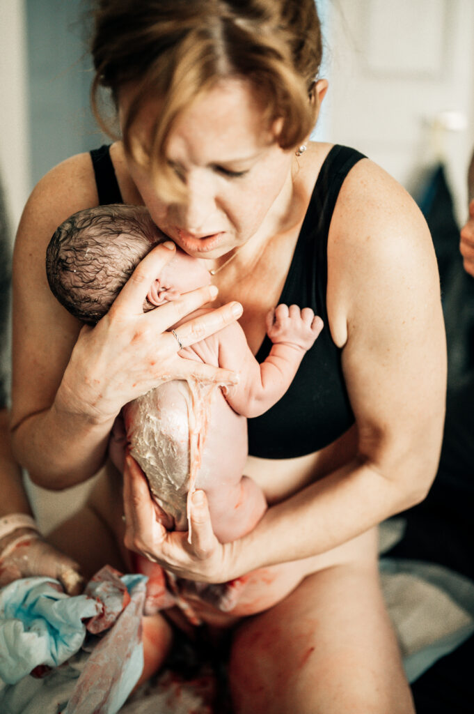 Baby held for the first time after birth photographed by DFW birth photographer Poppy Blue Photography Fort Worth